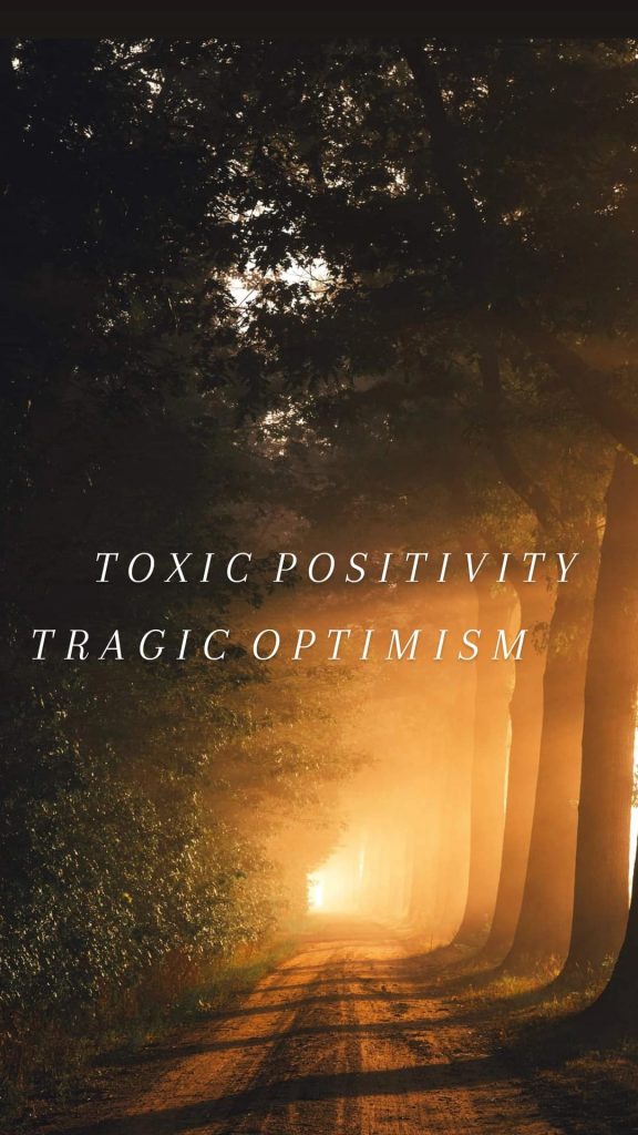 A ray of sunlight in the woods with the words "toxic positivity" and "tragic optimism"