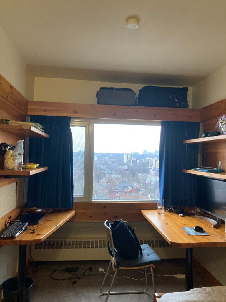 wooden desks in dorm room in front of window