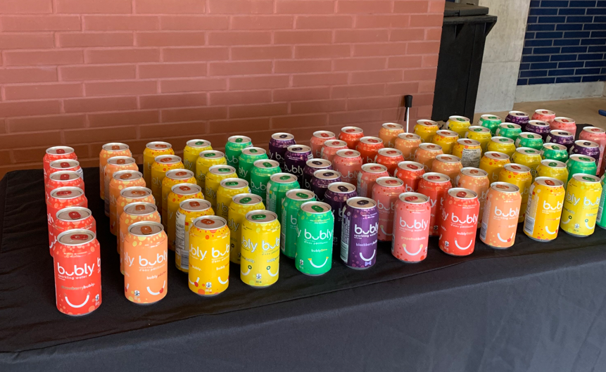Rows of rainbow-coloured pop cans.