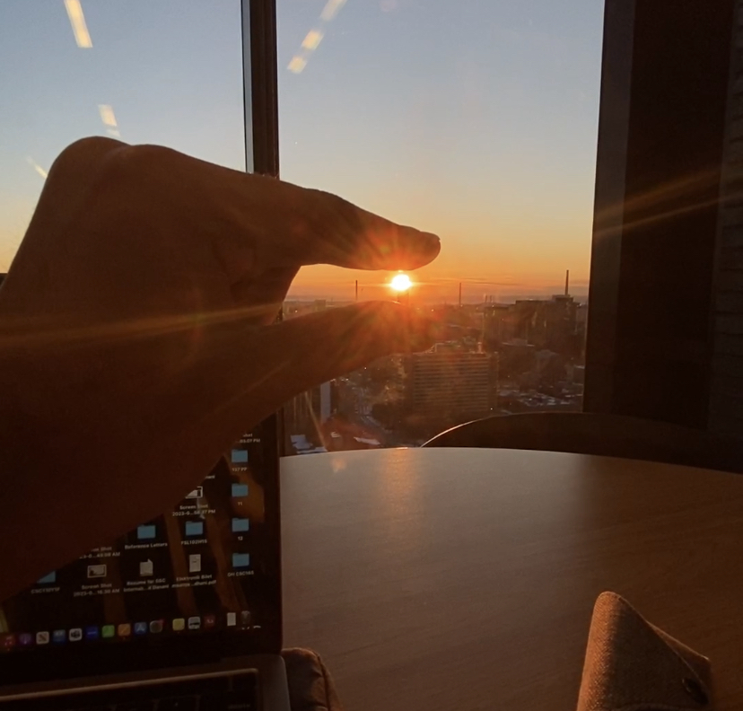 Photo of a person with their hand creating the illusion that they are "holding" the sun