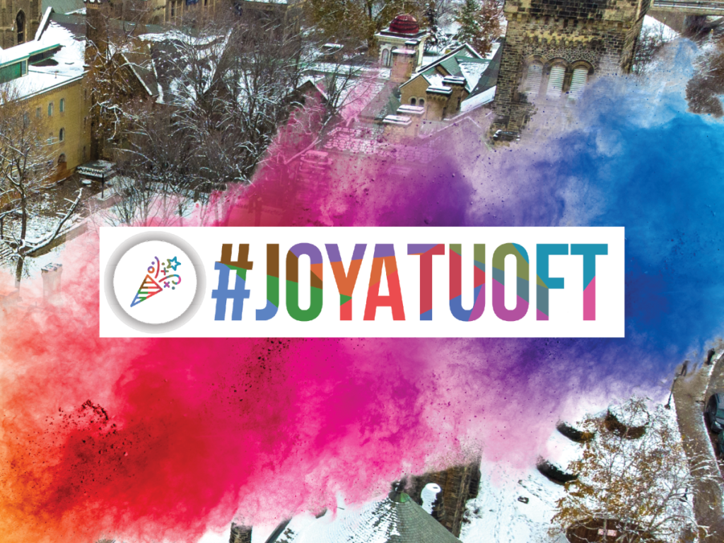 Photo of colourful dust in the air and buildings in the background with text: "#JoyatUofT"