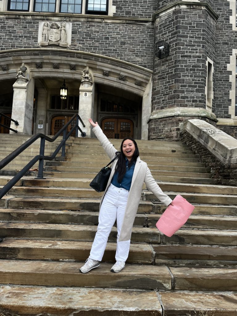 Jessica in front of steps of a school 