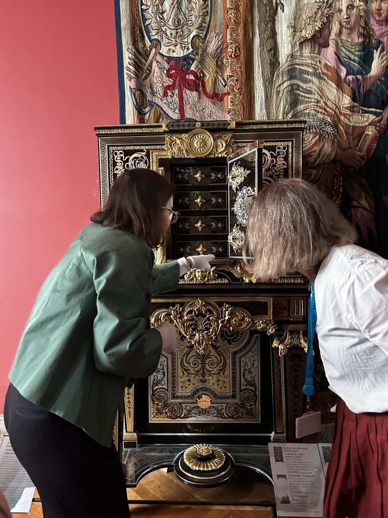 Annie pointing at a large chest of drawers