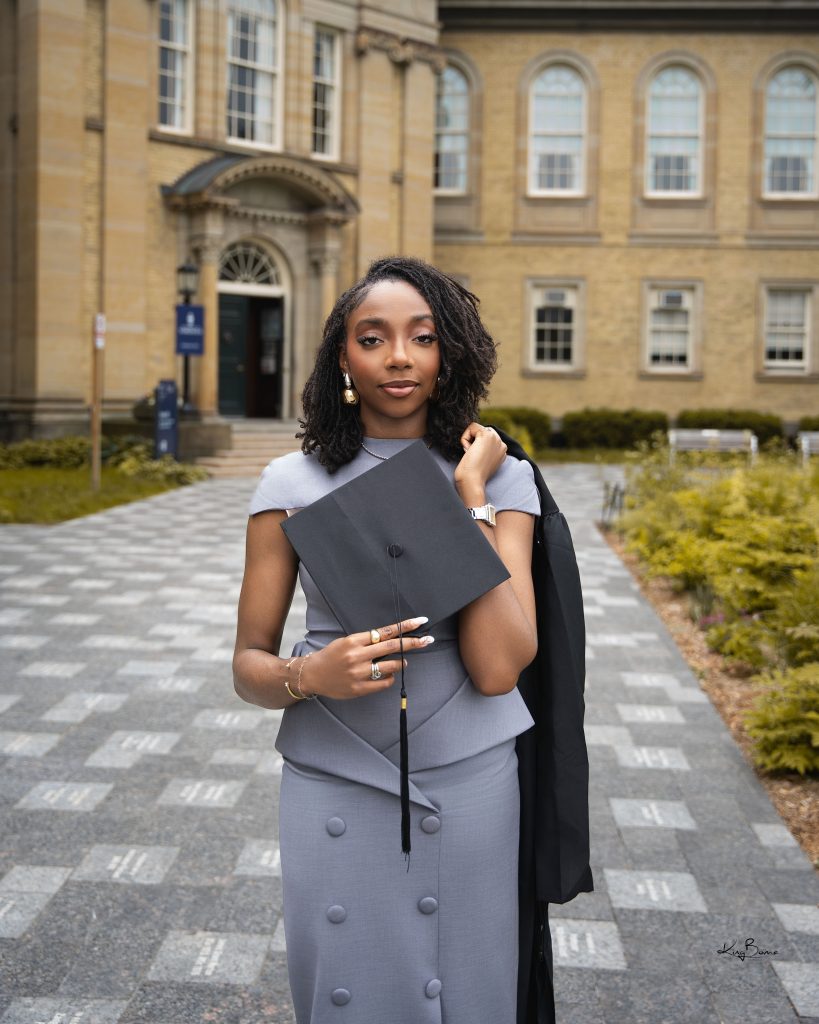 Student holding a graduation cap and gown